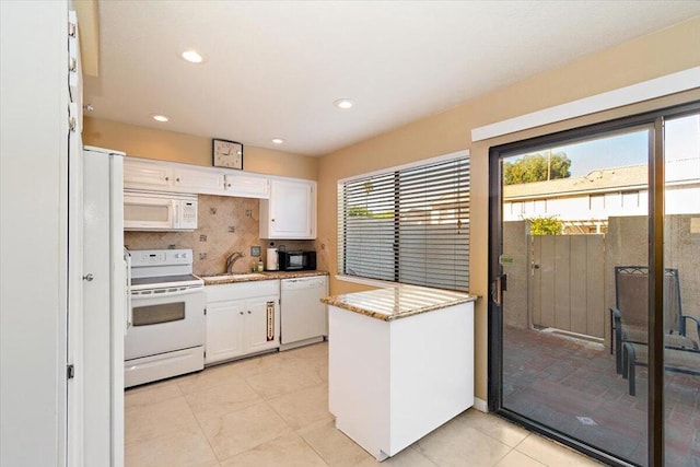 kitchen with white cabinetry, a healthy amount of sunlight, and white appliances