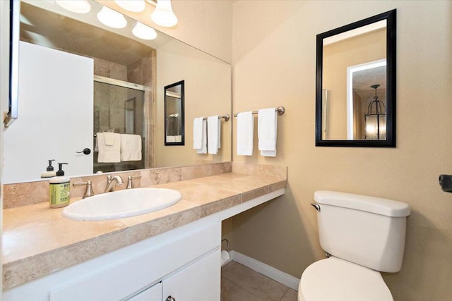 bathroom featuring tile patterned flooring, vanity, a shower with door, and toilet