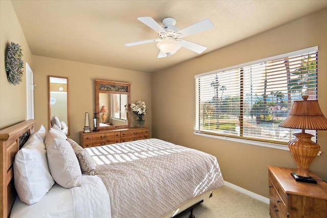 carpeted bedroom featuring ceiling fan and multiple windows