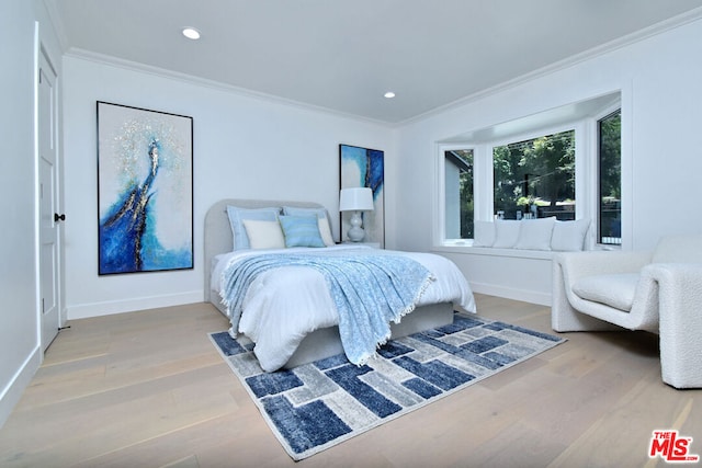 bedroom featuring light wood-type flooring and crown molding