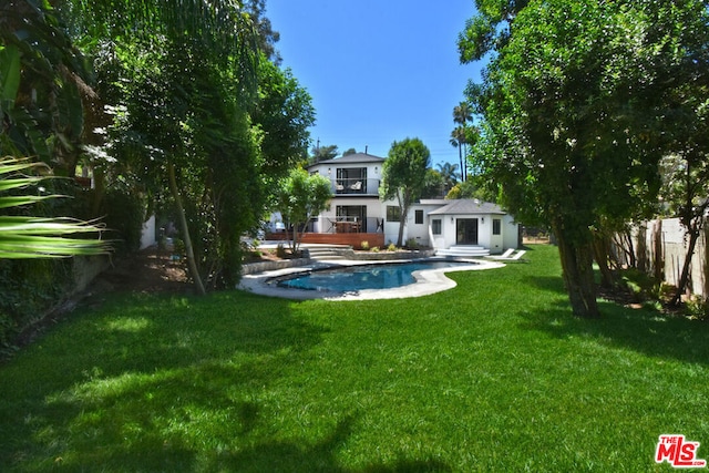 back of house featuring a fenced in pool and a yard