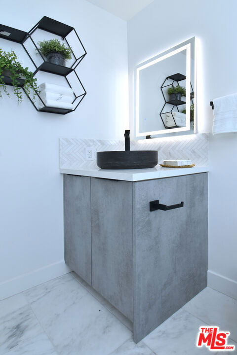 interior space with decorative backsplash and sink