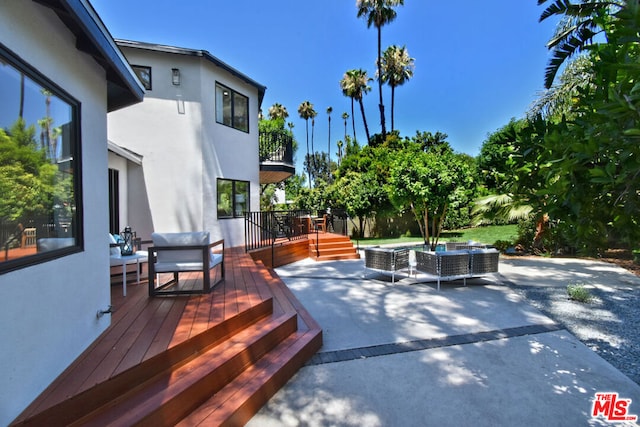 wooden terrace with an outdoor living space and a patio