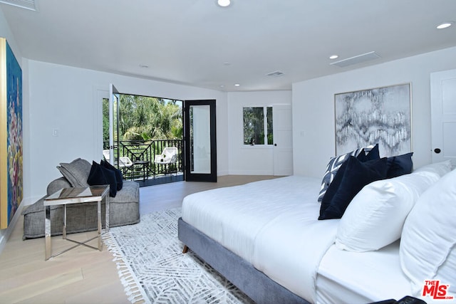 bedroom featuring light hardwood / wood-style floors, access to outside, and multiple windows