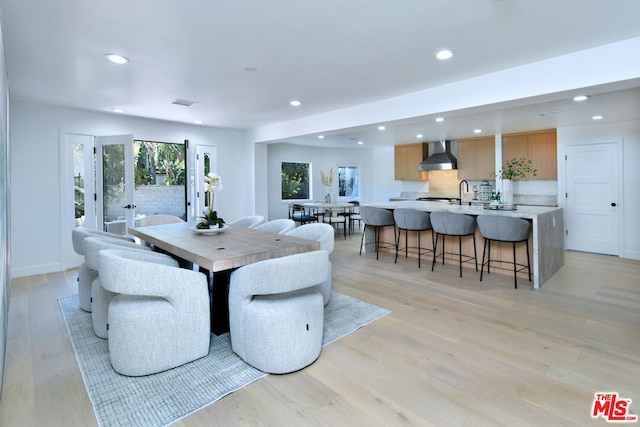 dining space with light hardwood / wood-style flooring and sink