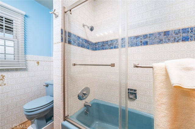 bathroom with shower / bath combination with glass door, tile walls, and toilet