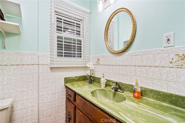 bathroom with vanity, tile walls, and toilet