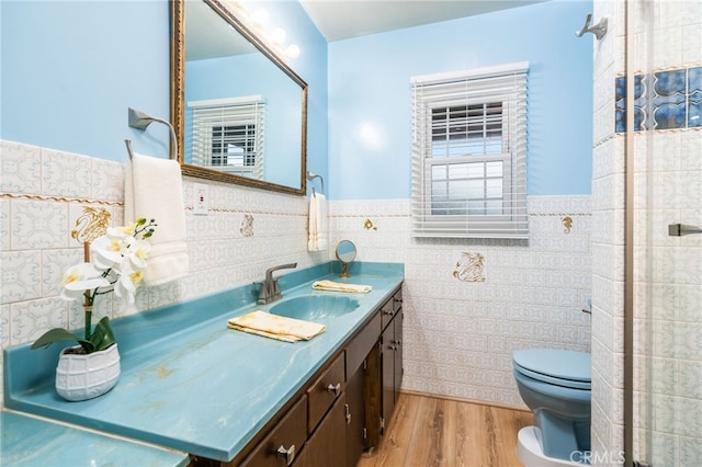 bathroom with vanity, wood-type flooring, and tile walls