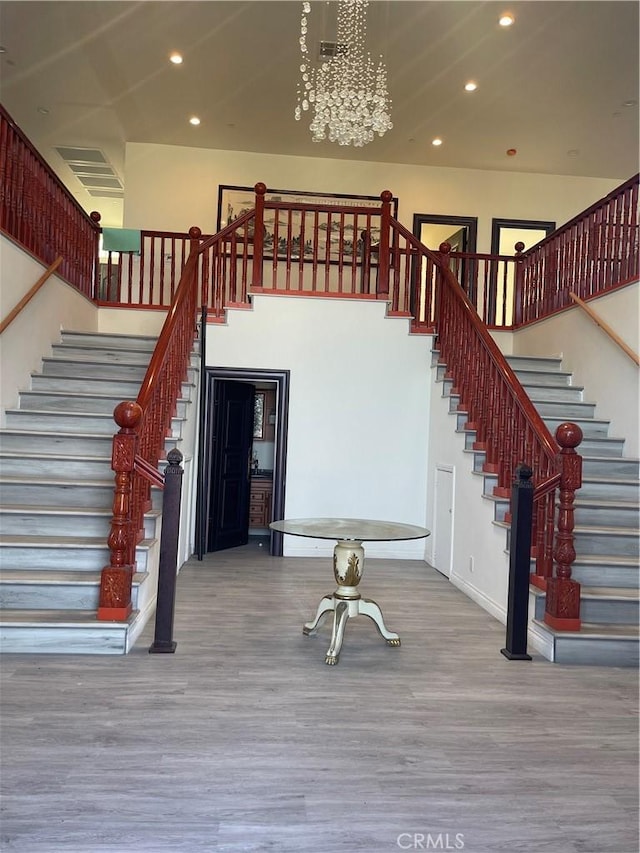 interior space with a chandelier, hardwood / wood-style floors, and a towering ceiling