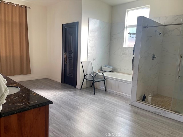 bathroom with hardwood / wood-style floors, vanity, and shower with separate bathtub