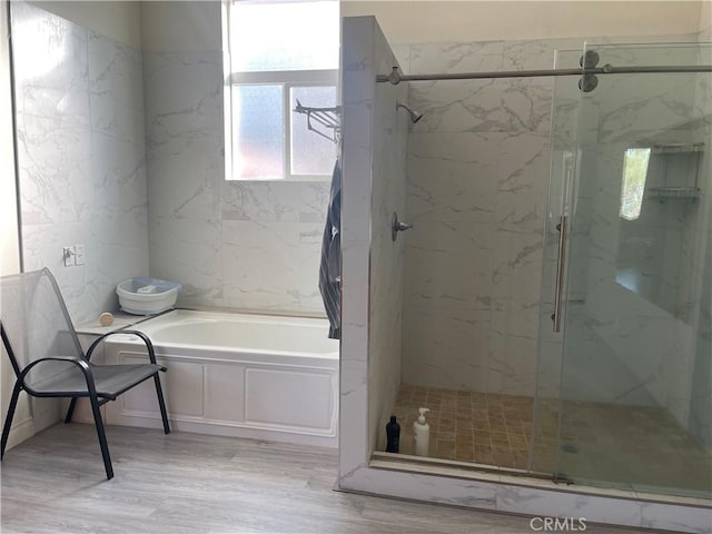 bathroom featuring separate shower and tub and wood-type flooring