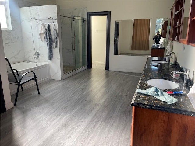 bathroom with hardwood / wood-style floors, vanity, and plus walk in shower