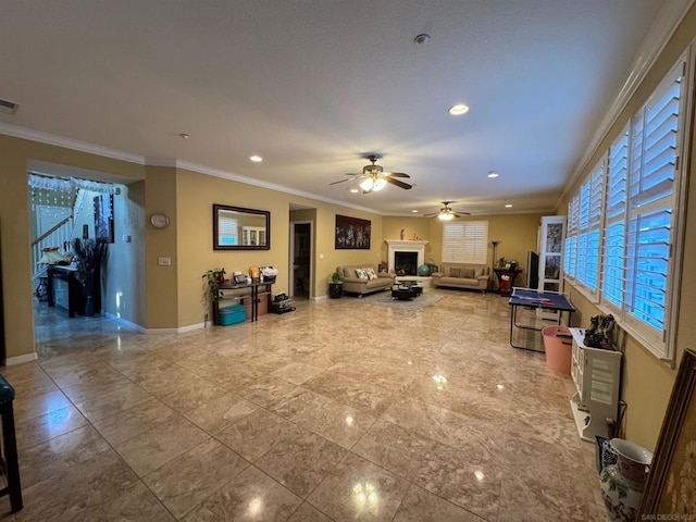 living room featuring ceiling fan and crown molding