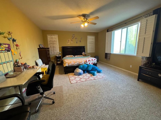 carpeted bedroom featuring ceiling fan and a textured ceiling