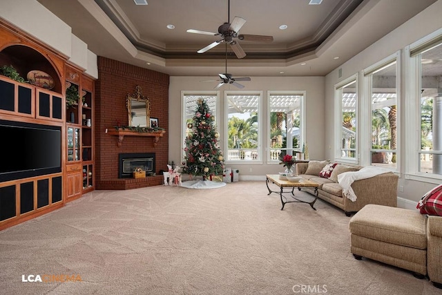 9120 Laramie Ave, Bakersfield, CA 93314 - carpeted living room featuring a tray ceiling, crown molding, a fireplace, and ceiling fan