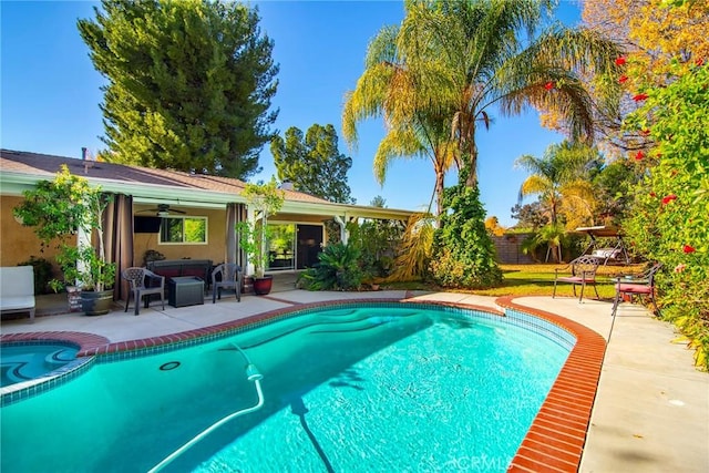 view of swimming pool with outdoor lounge area, ceiling fan, and a patio area