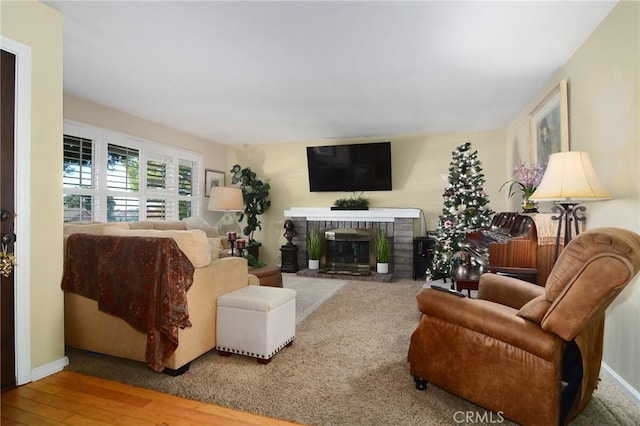 living room with wood-type flooring and a brick fireplace