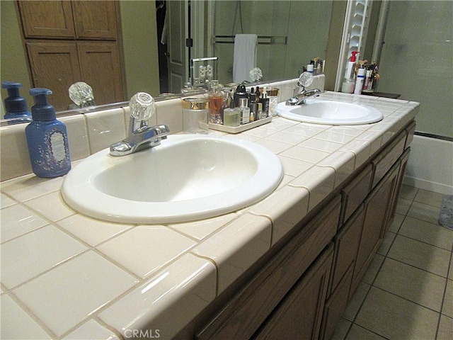 bathroom featuring tile patterned floors, vanity, and bath / shower combo with glass door