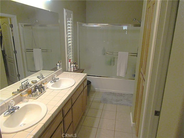 bathroom featuring tile patterned flooring, vanity, and enclosed tub / shower combo