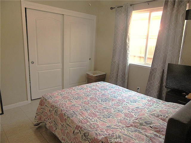 tiled bedroom featuring a closet and multiple windows