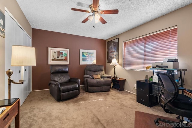 home office with a textured ceiling, carpet floors, and ceiling fan