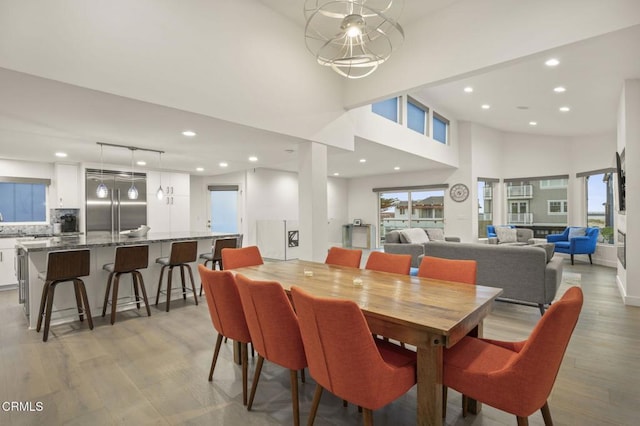 dining area with a high ceiling and light hardwood / wood-style flooring