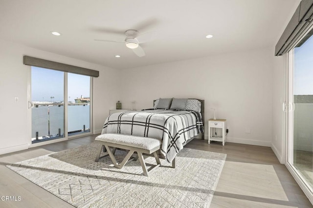 bedroom with multiple windows, ceiling fan, wood-type flooring, and access to exterior