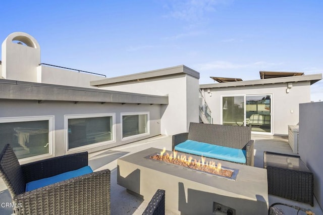 view of patio with an outdoor living space with a fire pit