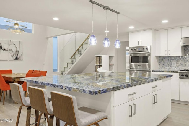 kitchen featuring a center island, dark stone countertops, and light wood-type flooring