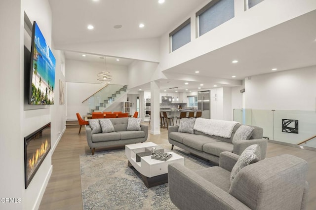 living room featuring hardwood / wood-style flooring and high vaulted ceiling