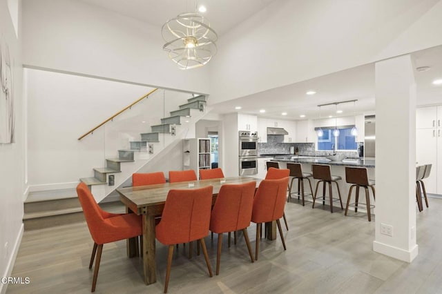 dining room featuring light hardwood / wood-style floors and a towering ceiling