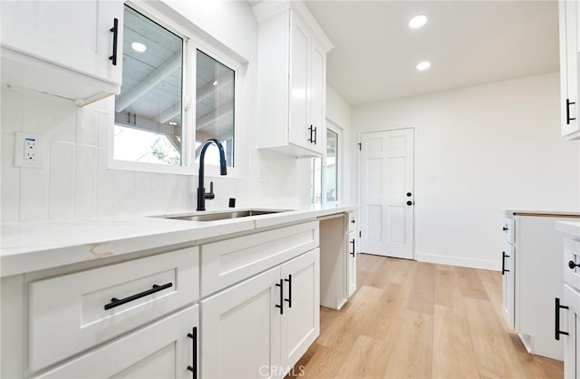 kitchen featuring white cabinetry, light hardwood / wood-style flooring, and sink