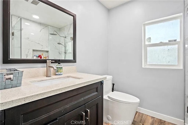 bathroom featuring vanity, toilet, wood-type flooring, and a shower with door