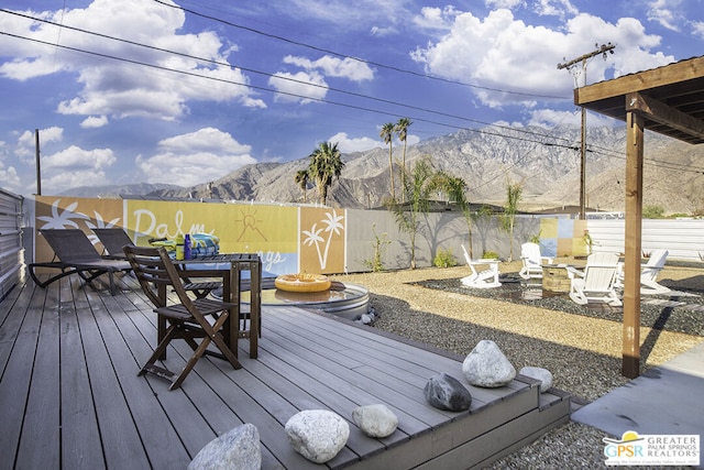 wooden terrace with a mountain view and an outdoor fire pit