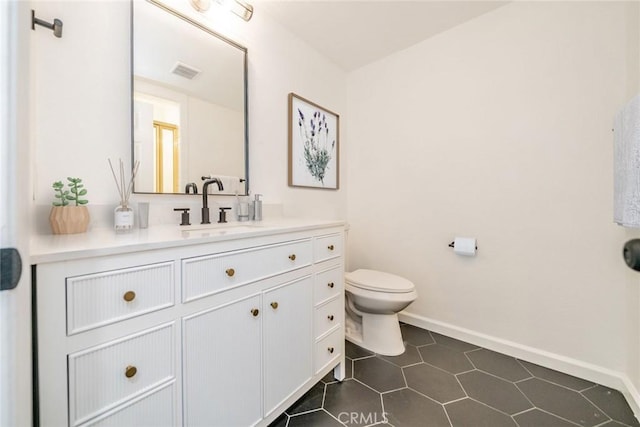 bathroom with tile patterned flooring, vanity, and toilet