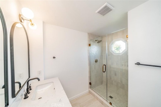 bathroom featuring vanity and a shower with door