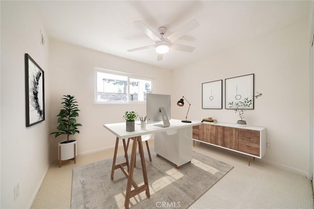 home office featuring light carpet and ceiling fan