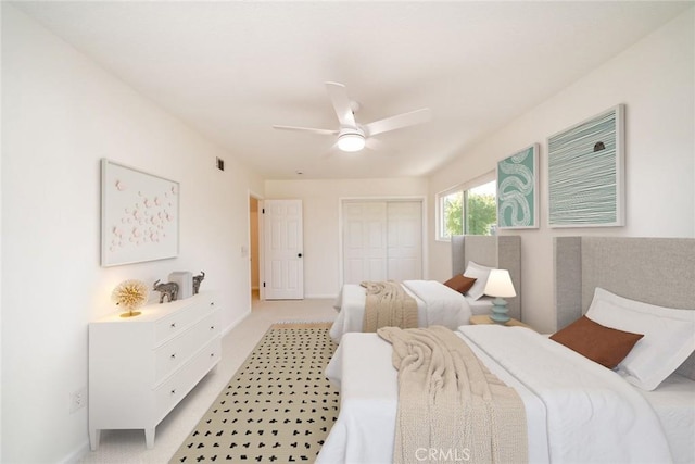 bedroom featuring ceiling fan, a closet, and light colored carpet