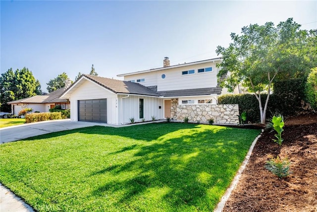 view of front of home with a front yard and a garage