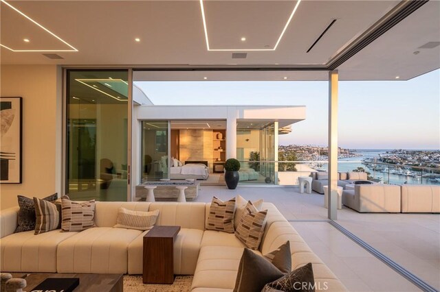 patio terrace at dusk featuring a water view and an outdoor hangout area