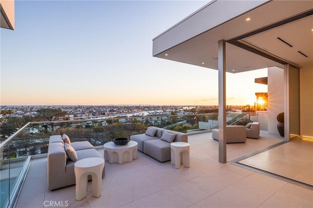 patio terrace at dusk featuring a balcony and an outdoor hangout area