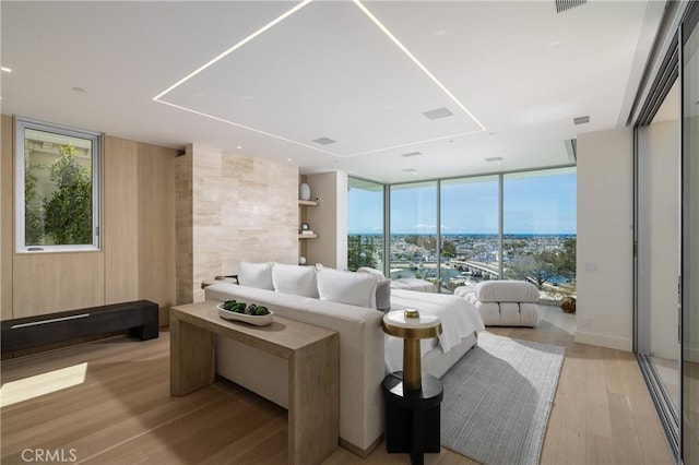 living room with floor to ceiling windows and light hardwood / wood-style flooring