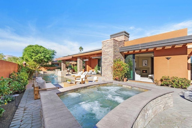 view of pool with pool water feature, a patio area, and an in ground hot tub