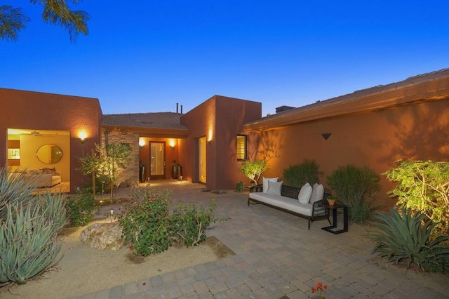 back house at dusk with a patio