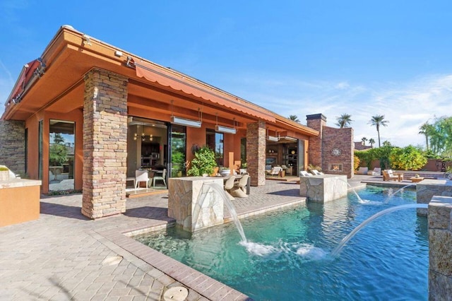 view of swimming pool featuring pool water feature and a patio