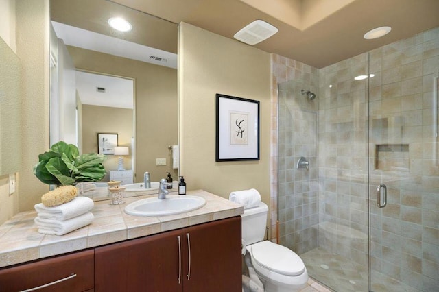 bathroom with toilet, an enclosed shower, and vanity