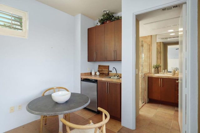 bar featuring stainless steel dishwasher, light tile patterned floors, and sink