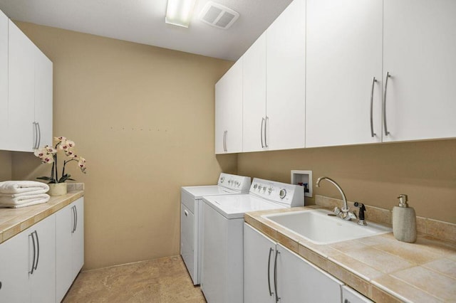 laundry area with cabinets, sink, and washing machine and clothes dryer