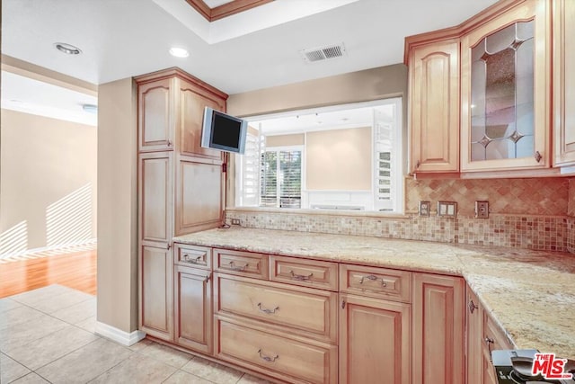 kitchen with decorative backsplash, light tile patterned floors, light stone counters, and crown molding