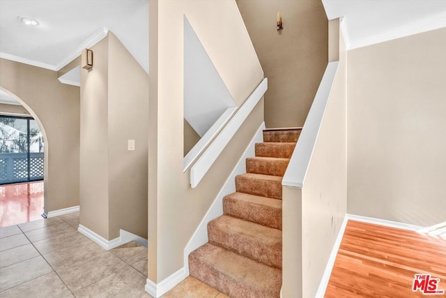 staircase featuring hardwood / wood-style flooring and ornamental molding